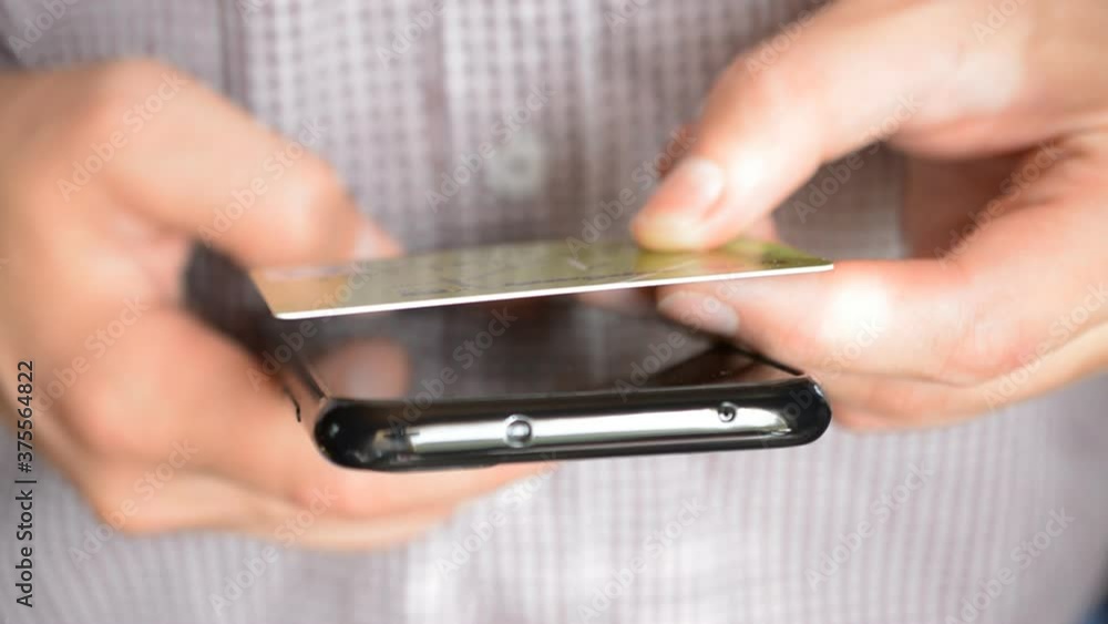 Man shopping online with credit card, Businessman inserting credit card number on mobile phone Man shopping online with credit card, Businessman inserting credit card number on mobile phone