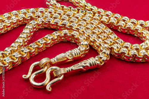 Golden necklace placed on the red velvet floor