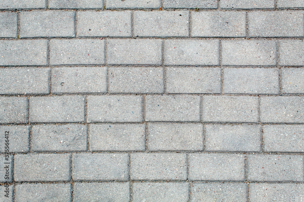 road paved with sidewalk tiles. texture of light gray bricks. road paved with sidewalk tiles. texture of light gray bricks.