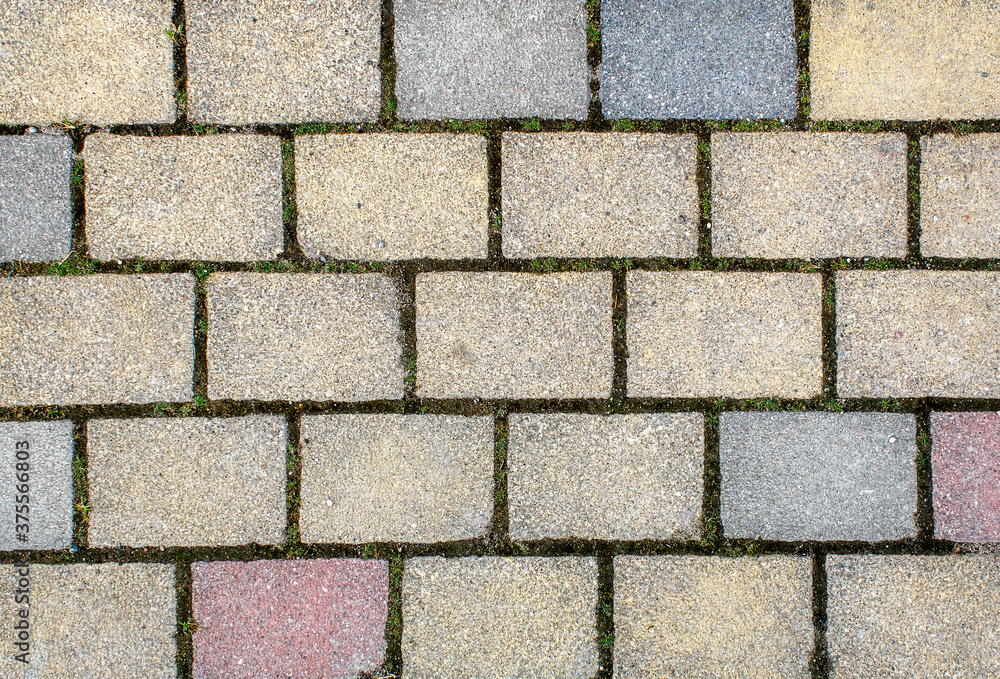 road paved with gray, yellow and brown sidewalk tiles. texture of light gray bricks. road paved with gray, yellow and brown sidewalk tiles. texture of light gray bricks.