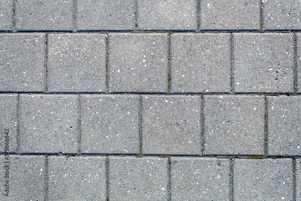 road paved with sidewalk tiles. texture of light gray bricks. road paved with sidewalk tiles. texture of light gray bricks.