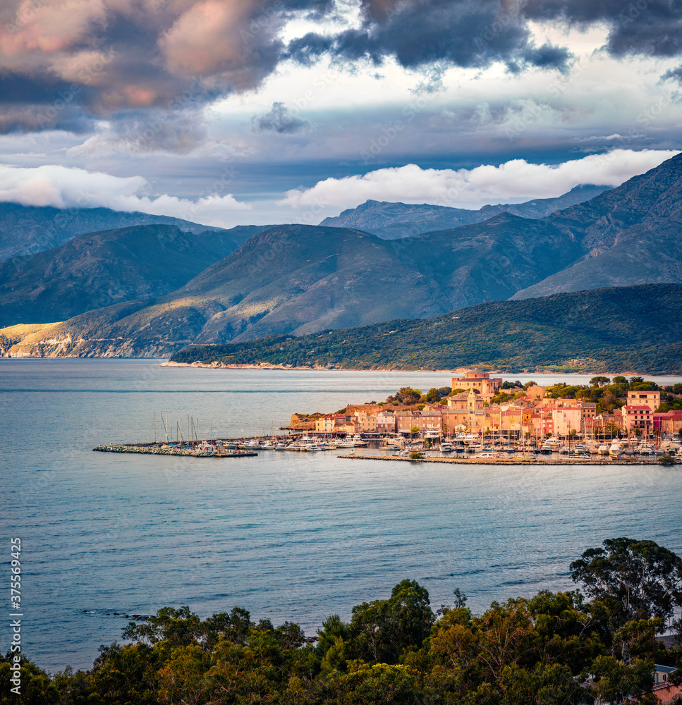 Gloomy spring view of Saint-Florent port, Haute-Corse department of France, Europe. Amazing sunset on Corsica island. Magnificent seascape of Mediterranean sea. Traveling concept background.
