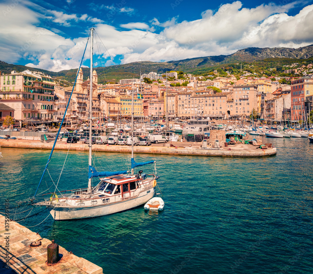 Sunny summer cityscape of Bastia port. Stunning morning view of Corsica island, France, Europe. Beautiful Mediterranean seascape with yacht and motorboat. Traveling concept background.