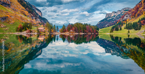 Stunning morning view of Seealpsee lake, Switzerland, Europe. Gloomy sky reflected in the calm waters of the lake. Beautiful autumn scene of Swiss Alps. Traveling concept background.