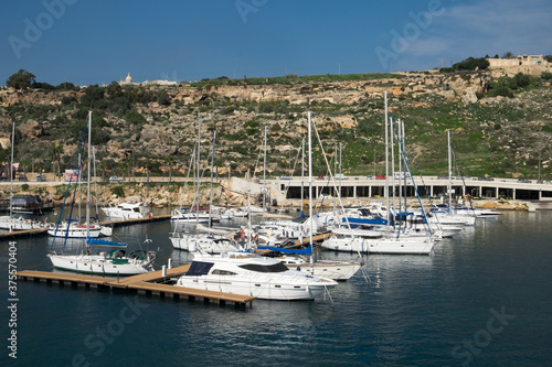 The ferry from Malta to Gozo island goes to the picturesque harbor of Mgarr port where the luxury yachts and traditional fishing boats are staying