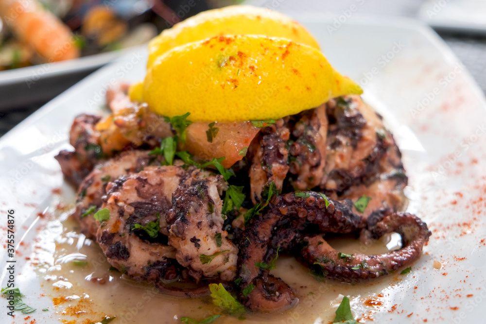 Delicious dish from traditonal cuisine of Malta island - freshly caught octopus grilled with garlic and olive oil and served with wine sauce
