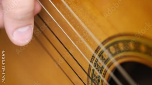 playing guitar brown close-up busting strings