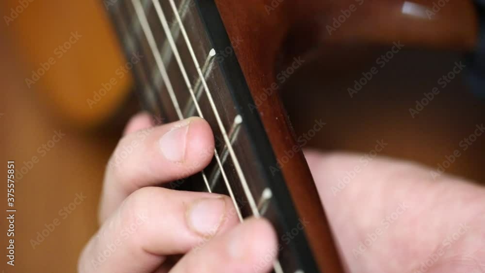 playing guitar close-up of strings and fingers