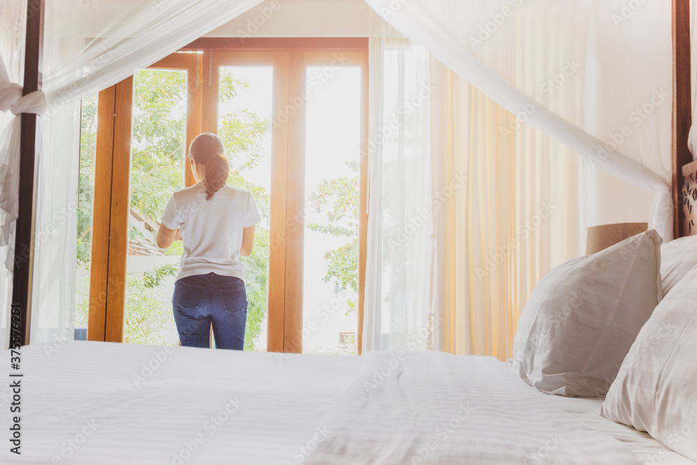 Asian women in hotel room open the window on summer vacation. Asian women in hotel room open the window on summer vacation.