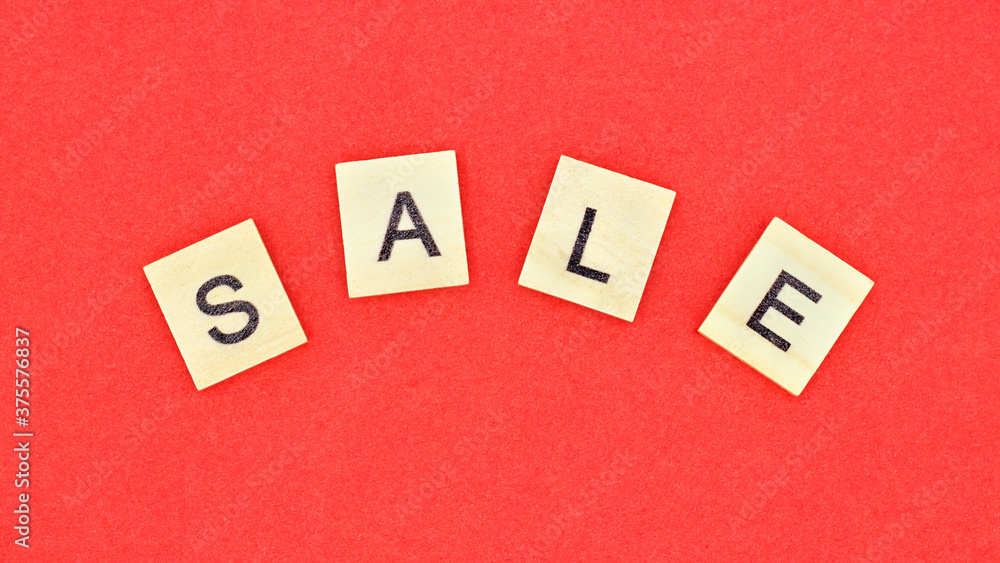 word SALE made of wooden letters on red background.Top view. Seasonal sale. word SALE made of wooden letters on red background.Top view. Seasonal sale.