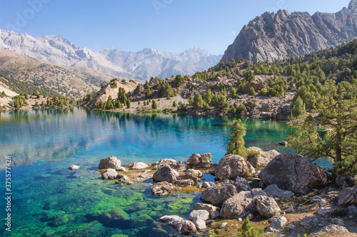 Tajikistan. Turquoise water in Alaudin lake. Beautiful view on rocky shore of lake in Fann mountains.  photo