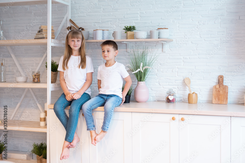 Little sister plays with her brother. Cute girl and boy are sitting at home. Little sister plays with her brother. Cute girl and boy are sitting at home.