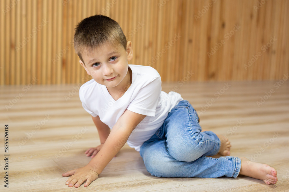 Cute little boy in white t-shirt posing. Portrait of a fashionable male child. Smiling boy posing. The concept of children's style and fashion.
