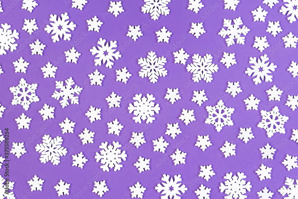 Top view of white snowflakes on colorful background. Winter weather concept with copy space. Merry Christmas concept Top view of white snowflakes on colorful background. Winter weather concept with copy space. Merry Christmas concept