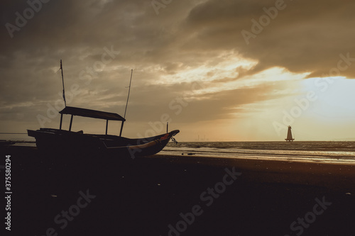 Silhouette boat and tree at sunset,