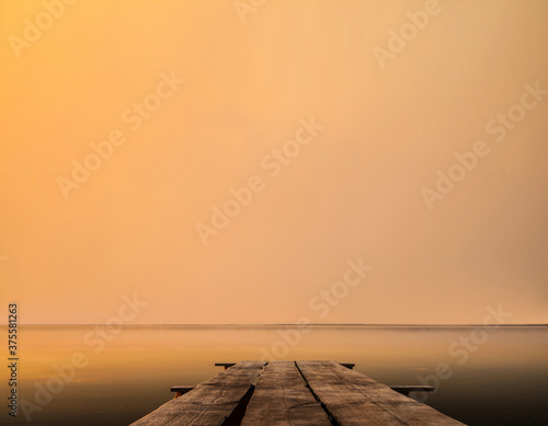 Golden sea sunset on the wooden pier. wooden path access pontoon sunrise water reflection on Lake Hourtin in mirror image photo