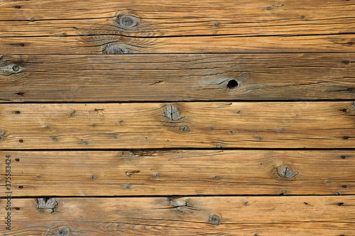 Wooden floor made of old boards with knots and cracks with rusty nails