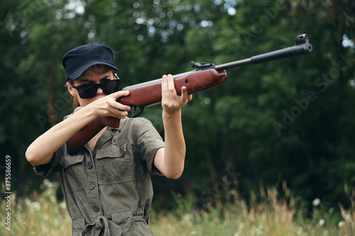 Woman soldier Sunglasses weapon aiming hunting green leaves 