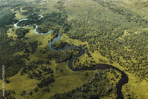 A winding river flows among forests and meadows. Drone shot © Vladimir