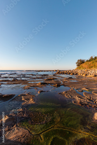 Rocky and mossy coastline at Coalcliff Beach, Sydney, Australia.