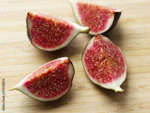 Spread the halves of the figs on a wooden surface. Delicious breakfast with figs, delicacies, proper nutrition, good morning, snacks, juicy fruit halves. The benefits and harms of figs