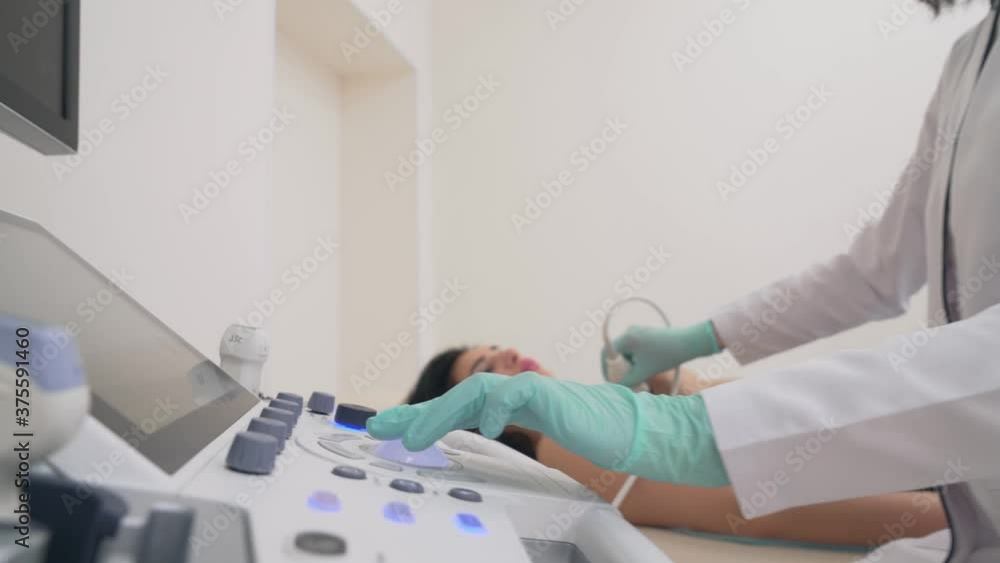 Mammologist examining breast with ultrasound device. Mammologist examining breast with ultrasound device.