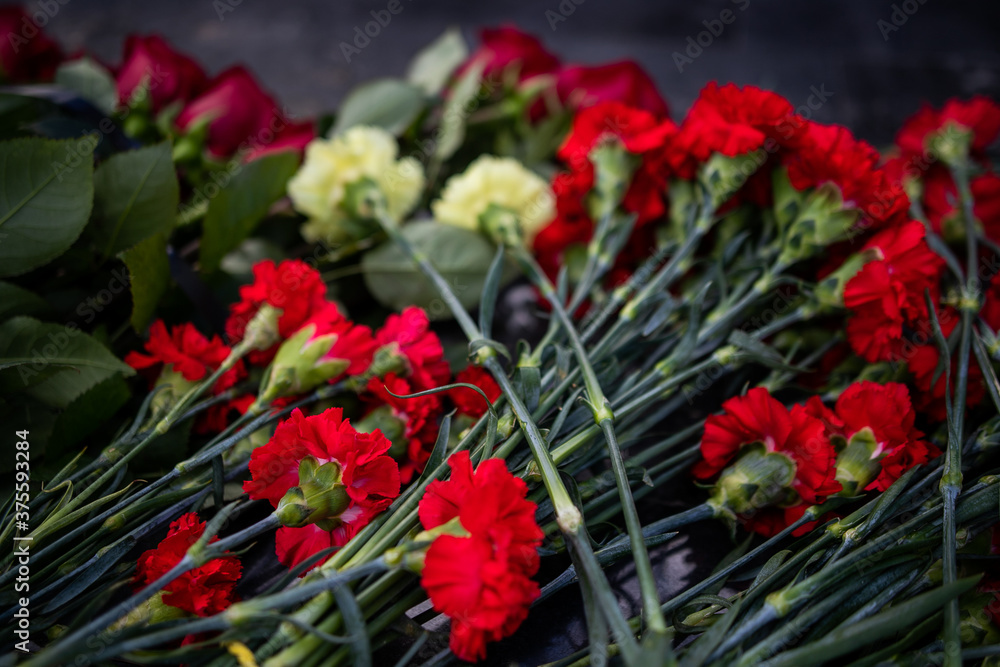 Flowers lie on a granite monument, laying flowers on the day of remembrance and mourning. Flowers lie on a granite monument, laying flowers on the day of remembrance and mourning.
