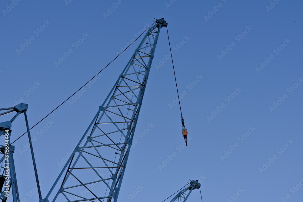 Arm of a heavy lift steel crane with blue skies.