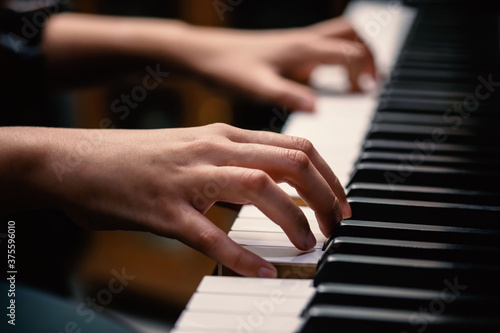 young woman performer hands playing piano.
