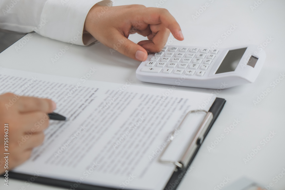 Financial auditor calculating with valuation data report. Financial auditor calculating with valuation data report.