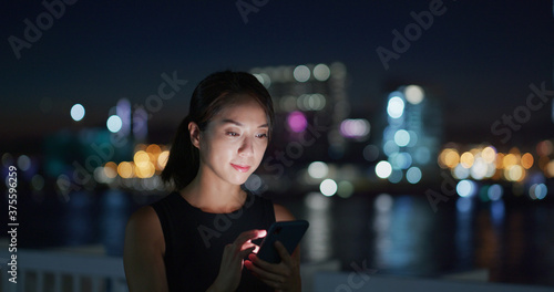 Canvas Print Businesswoman use of smart phone in city at night