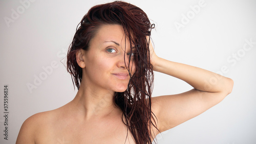 Portrait of a Caucasian woman with wet hair on a white background.