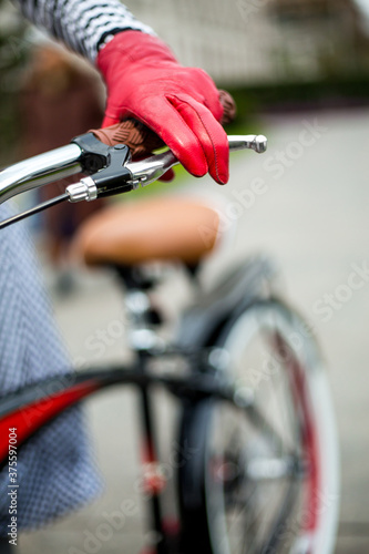 Young woman with bicycle on the street with red gloves, hat and scarf