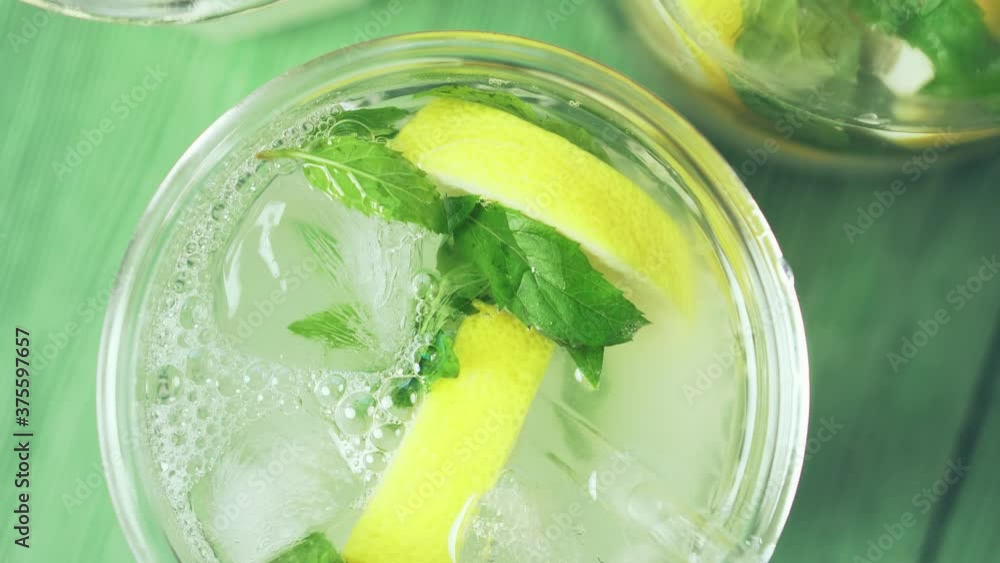 Fresh cold lemonade with mint and ice, top view. Delicious lemon cocktail, close-up. Fresh cold lemonade with mint and ice, top view. Delicious lemon cocktail, close-up.