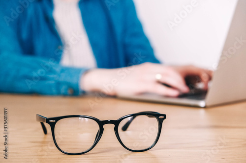 Eye glasses on work desk with laptop at business workplace. Copy, empty space for text