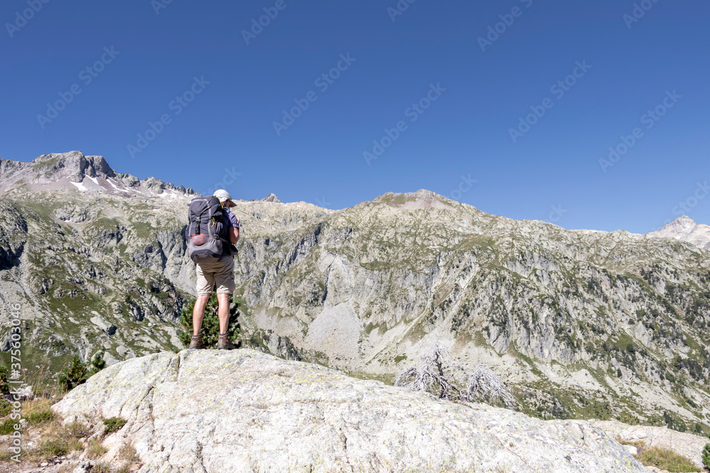 Man hiking in mountains. Hiking in Pyrenees National Park, Hautes-Pyrenees, Occitanie in south of France France Man hiking in mountains. Hiking in Pyrenees National Park, Hautes-Pyrenees, Occitanie in south of France France