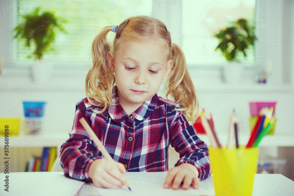 Portrait of pretty school girl are studying at classroom at the table Portrait of pretty school girl are studying at classroom at the table