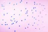 Colorful confetti on pink background with light bokehs. Happy new year celebration party. Greetings and congratulation concept. Festive backdrop with copy space for your design
