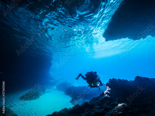 Seascape of coral reef in the Caribbean Sea / Curacao with Diver in cave "Blue Room"