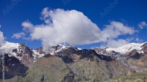 An isolated cloud above the peak of the mountain in the italian alps (Trentino, Italy, Europe)
