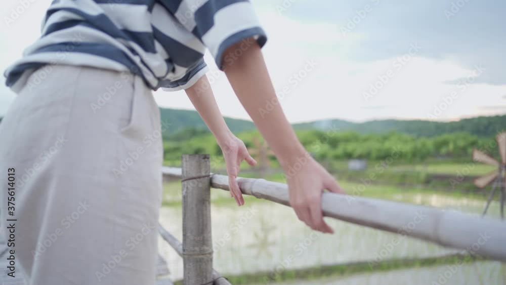 young female standing on wooden bridge, rest arm on wood hand rail, Asian country side farmer village, rice paddy field blur background, tranquil scene non urban clear weather sky on the sunny day young female standing on wooden bridge, rest arm on wood hand rail, Asian country side farmer village, rice paddy field blur background, tranquil scene non urban clear weather sky on the sunny day