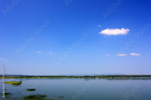 Calm blue surface of a lake under a blue sky © kos1976