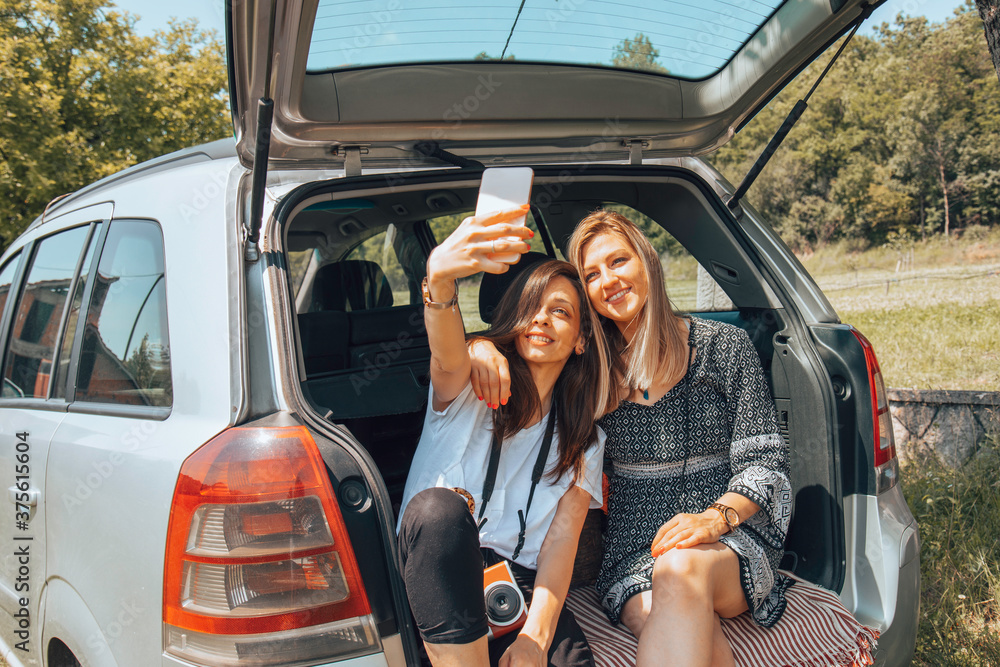 Two female friends travel around the world in a car. Vacation concept. Two female friends travel around the world in a car. Vacation concept.