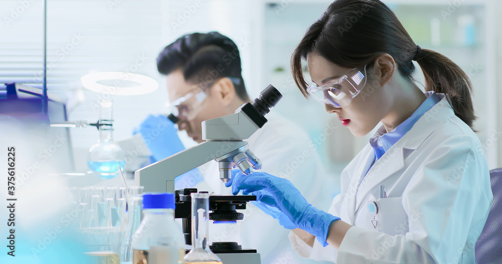 Asian scientist use microscope Asian scientist use microscope