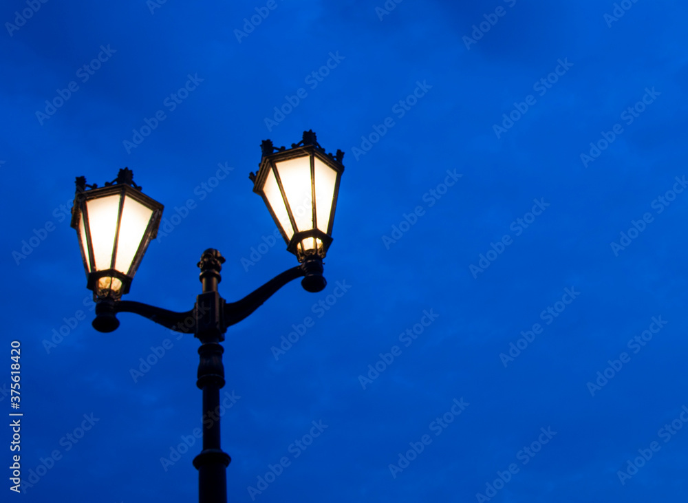A bright yellow lantern against a dark sky. Background for Halloween.