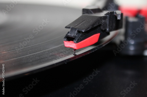 record player stylus arm on vinyl rotating disc background with copy space, record player needle with copy space below 
