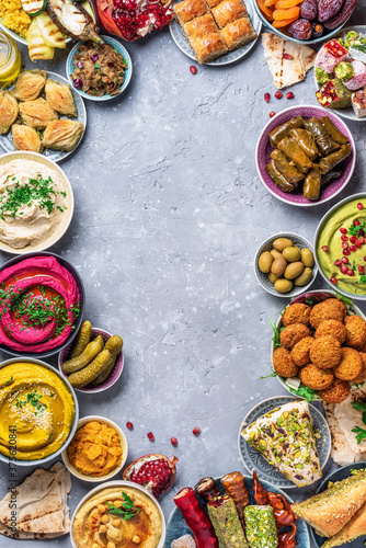 Mediterranean appetizer concept. Arabic traditional cuisine. Middle Eastern meze with pita, olives, hummus, stuffed dolma, falafel balls, pickles, babaganush, vegetables, pomegranate, eggplants