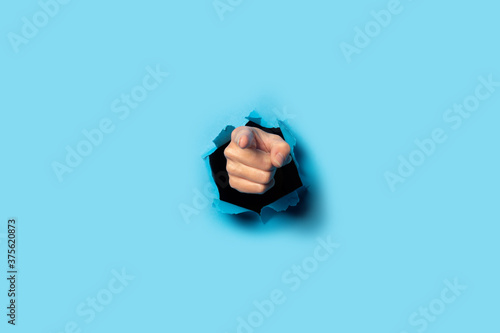 Valokuva Hand points to something on a blue background