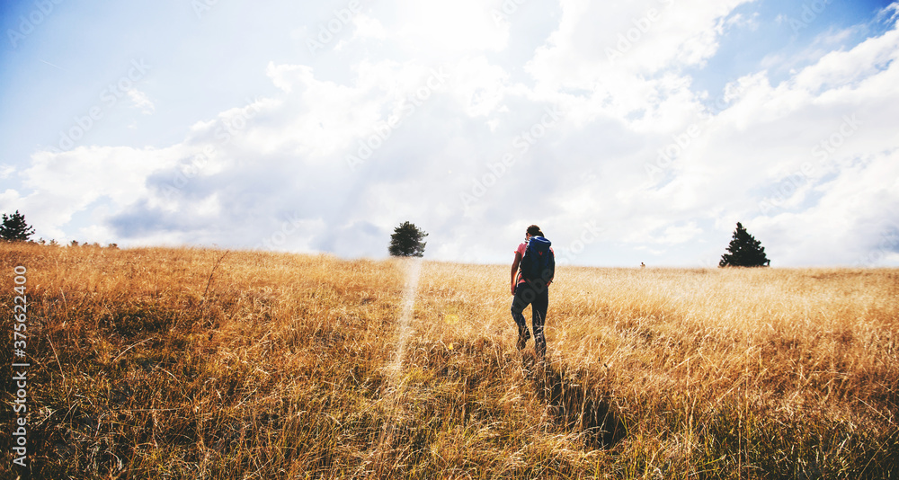 Unrecognizable female with rucksack hiking