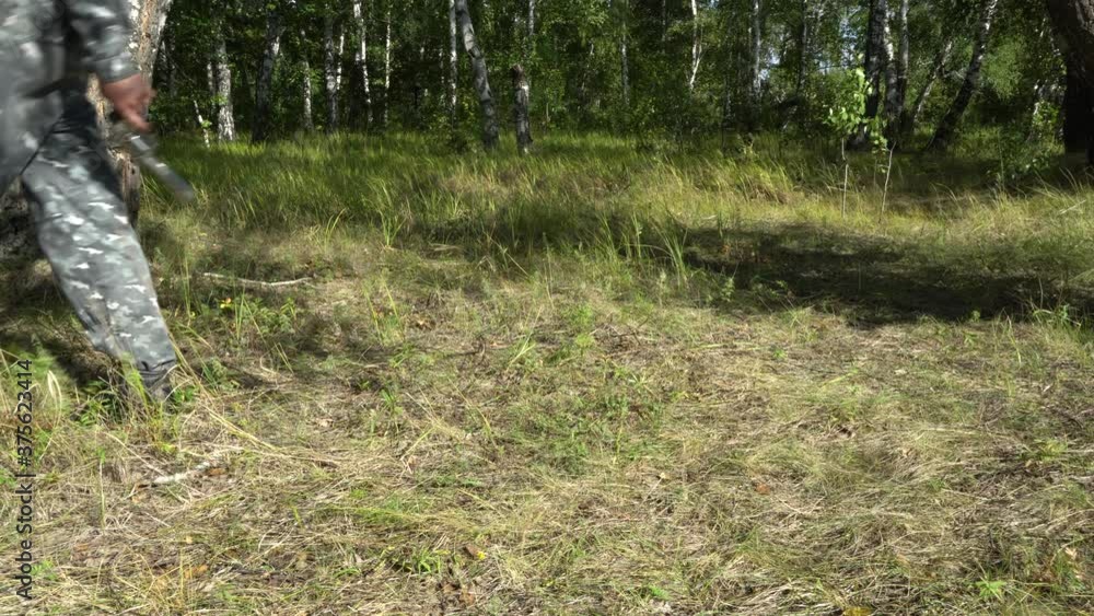 A military man in a camouflage protective uniform walks through the ...